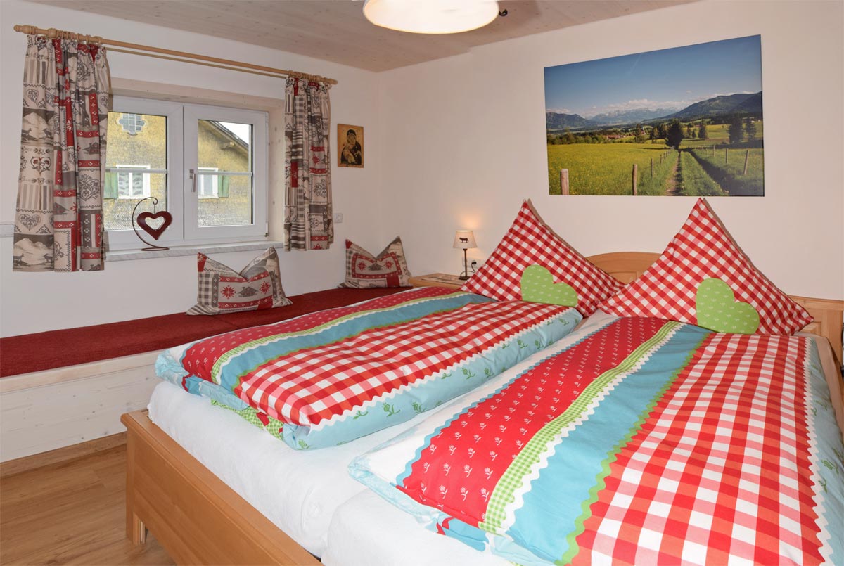 Schlafzimmer mit Doppelbett und langer Sitzbank